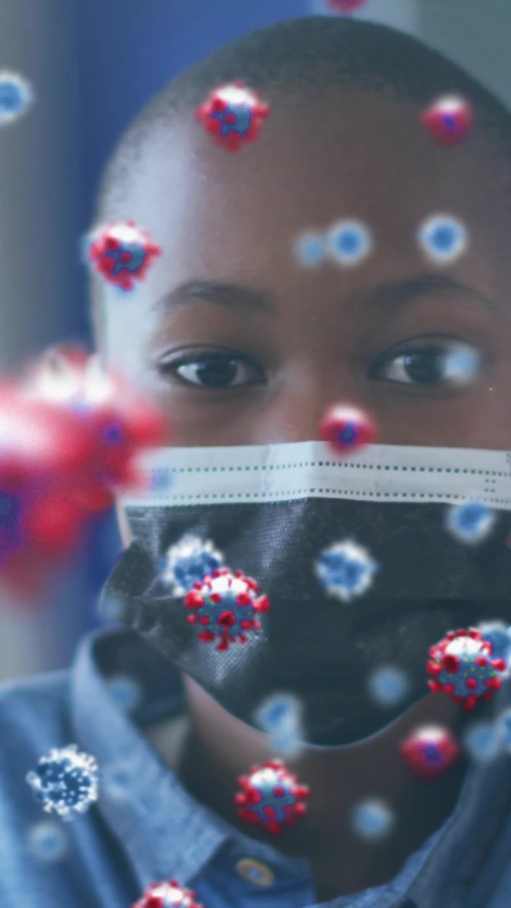 Animation of covid 19 cells over african american schoolboy in face mask