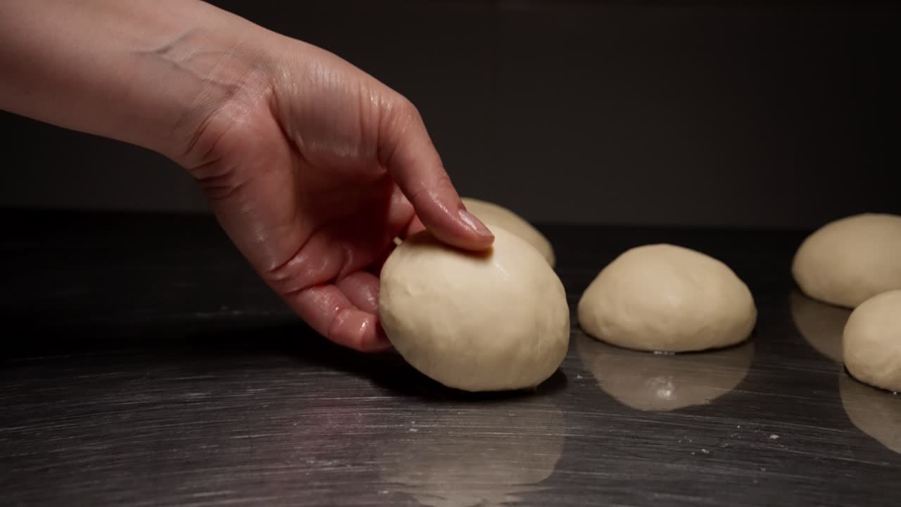 Close-Up of Hand Pressing Raw Dough Ball for Baking