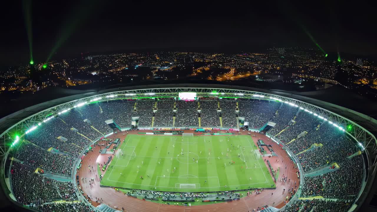 Wide-angle video capture of a vibrant nighttime soccer match in a packed stadium