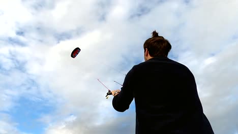 un hombre volando una cometa en lo alto de un cielo nublado