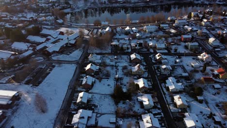 Quick-aerial-pan-across-suburban-homes-covered-in-light-dusting-of-snow,-Sweden