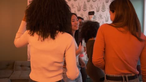 happy diverse friends dancing while enjoying weekend party at home