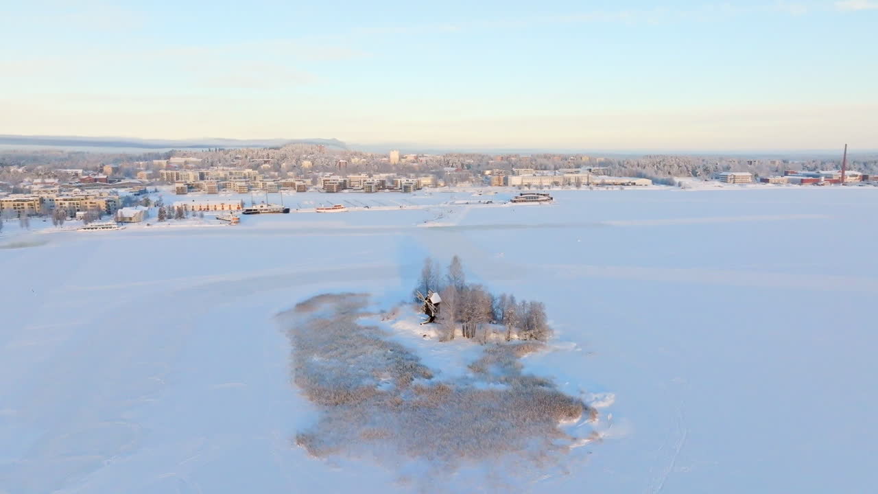 Aerial view away from the Vasikkasaari island, winter sunrise in Kuopio, Finland