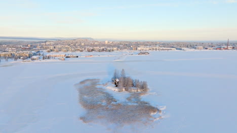 aerial view away from the vasikkasaari island, winter sunrise in kuopio, finland