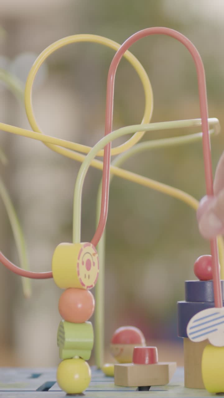 Close-up of colorful wooden toy bead maze in a playful setting