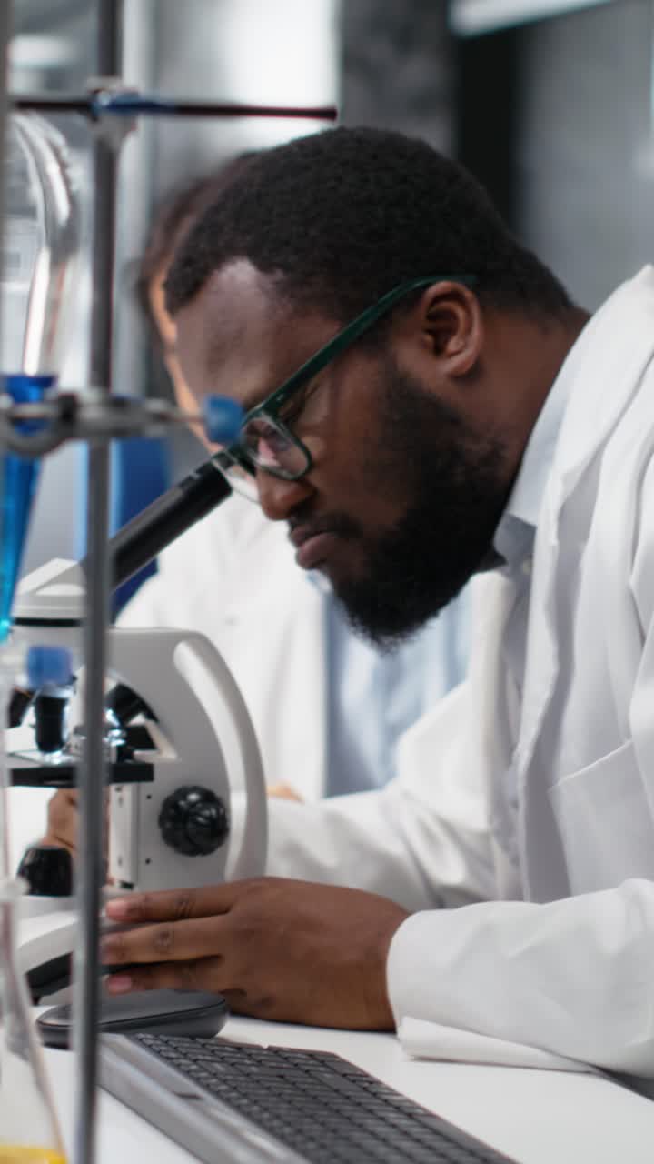 Vertical video Multiethnic nanotechnology researchers using microscope