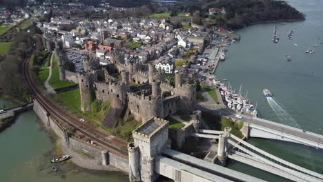 una vista aérea del castillo de conwy en un día soleado, volando de izquierda a derecha alrededor del castillo con la ciudad al fondo, al norte de gales, reino unido