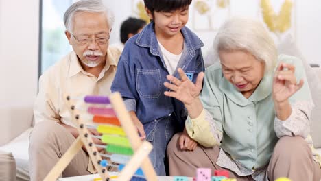 Elderly couple and young boy enjoy a colorful game together, creating joyful moments in a bright, cozy living room