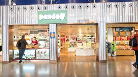 people walking past a shop in shanghai airport