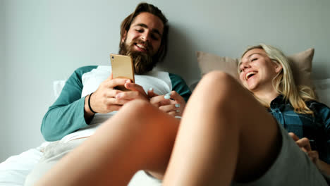 couple interacting while using mobile phone on bed at home 4k