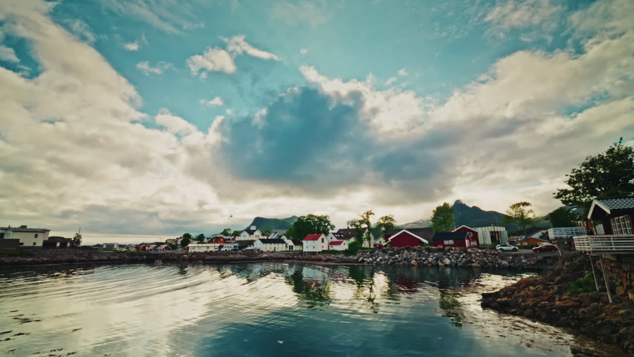 Panoramic view of a local nordic town in Norway. View of the wooden local buildings and the picturesque landscape. Sky reflecting on the still water.