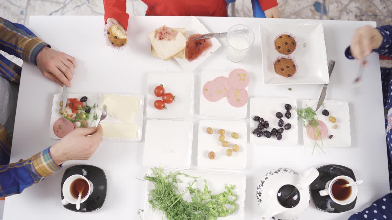 가족들은 잠옷을 입고 테이블 주위에 앉아 함께 아침 식사를 즐기고 있습니다.