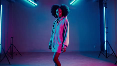 vibrant portrait of a young woman with afro hair in neon lighting