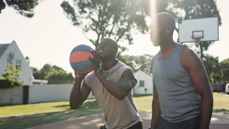 two men playing basketball outdoors