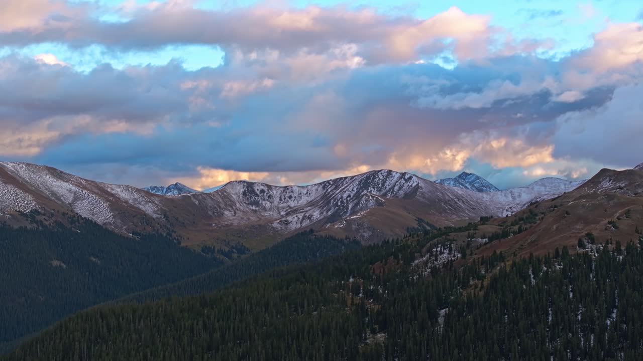 Aerial view of a vast lake reflecting the mountain ranges under soft morning light in Colorado