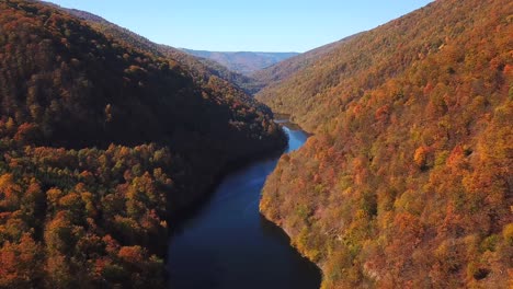 Aerial-view-of-lake-Tarnita,-Romania,-surrounded-by-colorful-autumn-trees