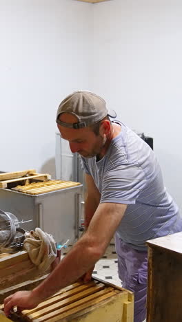 male apiculturist replaces honey frames from one box to another. preparing honeycombs for honey extraction. vertical video