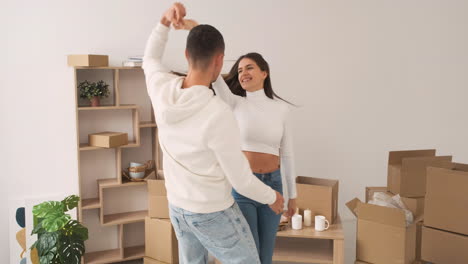 vista frontal de una joven pareja feliz bailando juntos en una nueva casa 1