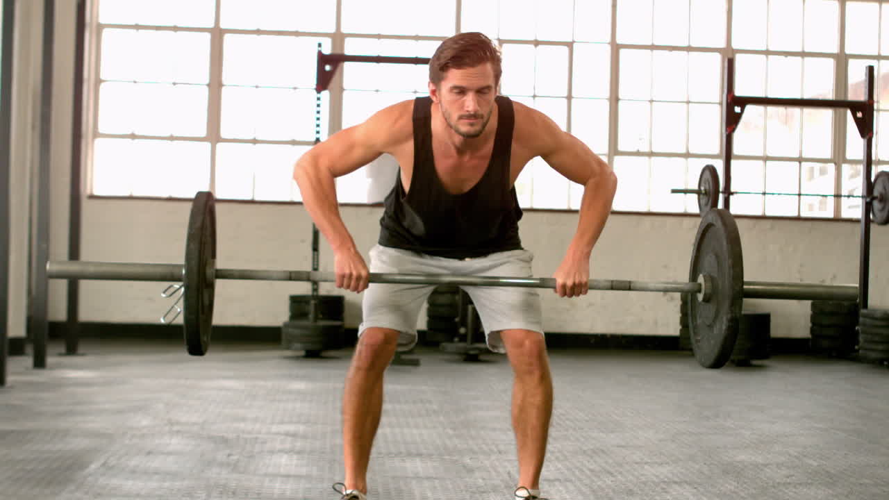 hombre en forma levantando pesas pesadas