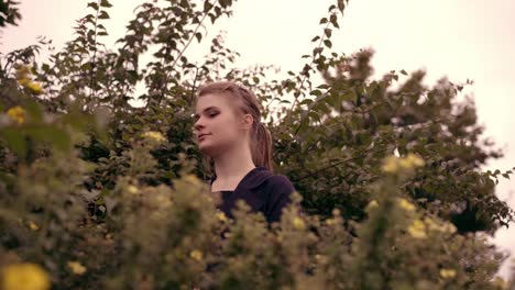 Beautiful-girl-from-behind-the-bushes-with-yellow-flowers