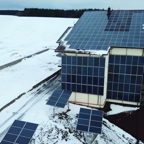 aerial solar farm low flight in winter. series of solar panels covered with snow.