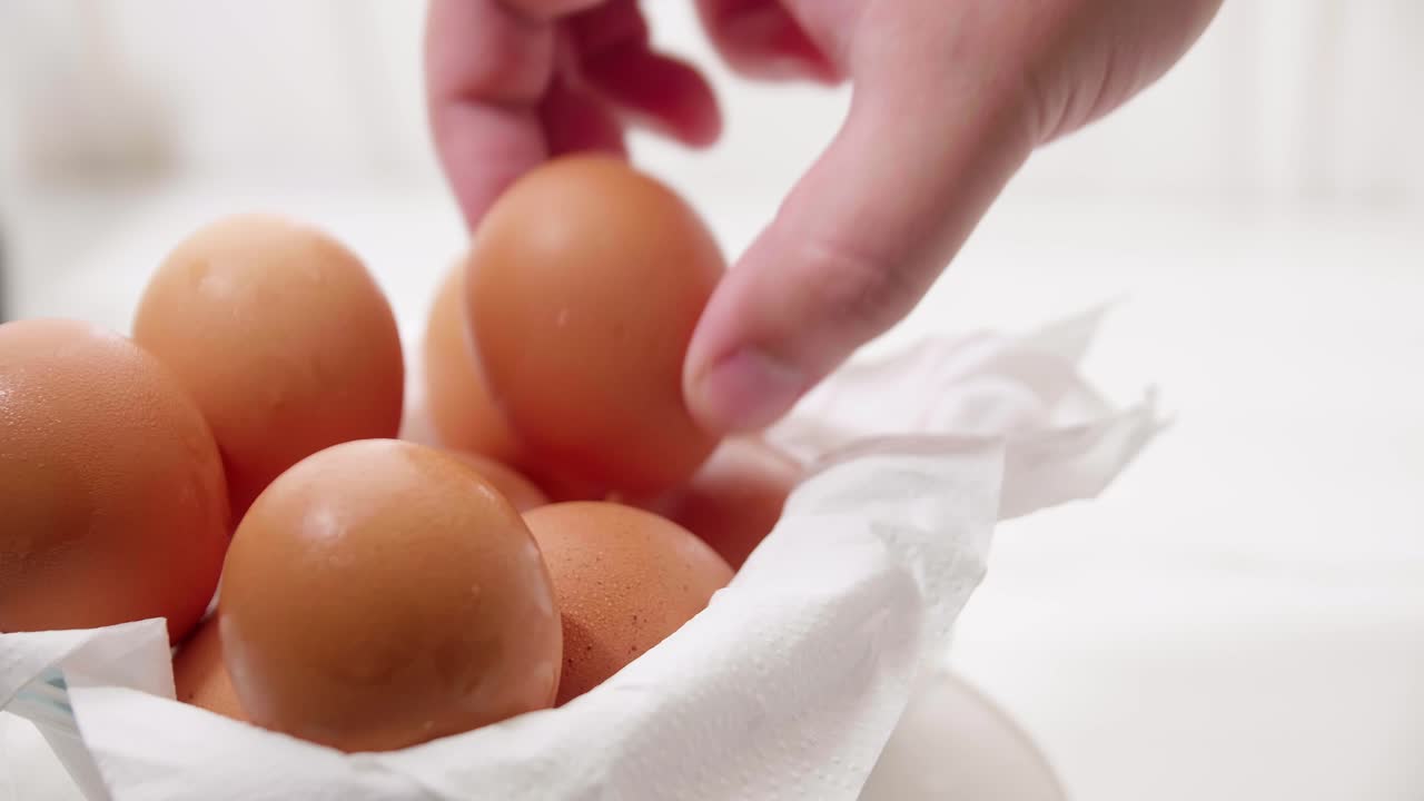 Close up male hand taking brown eggs out of the carton