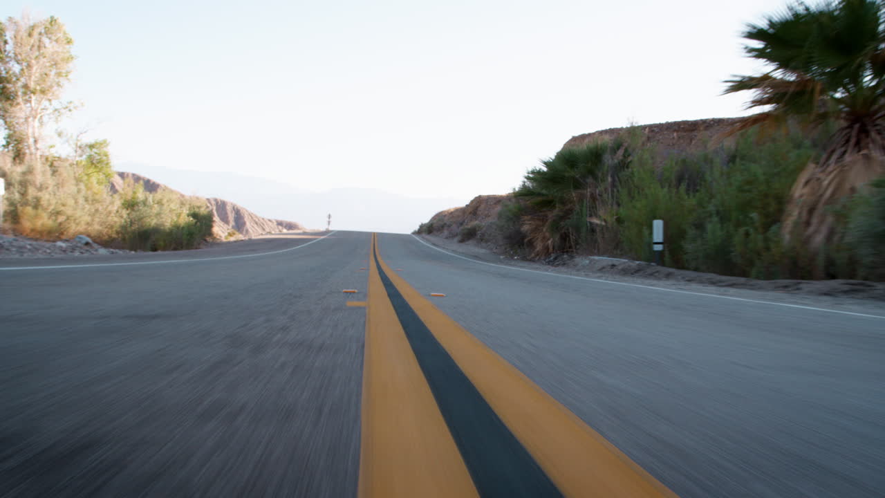 Ripresa dal basso che guarda indietro verso la strada da un veicolo in movimento