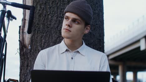 young man working on laptop outside