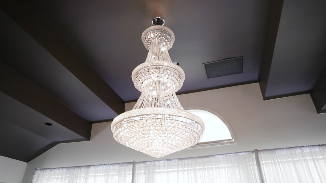 아름다운 결혼식 피로연 장소의 창문 앞에 있는 크리스탈 계단식 샹들리에 악센트