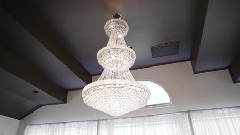 crystal cascading chandelier accent in front of a window in a beautiful wedding reception venue