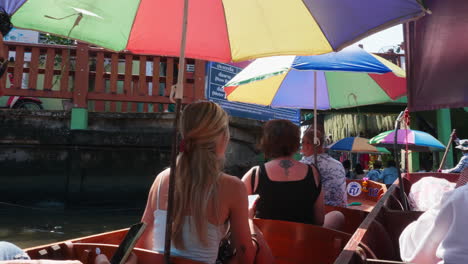 people touring a thai floating market by boat