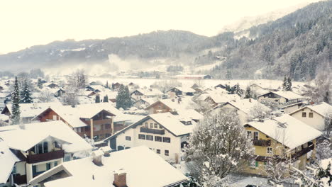 snowy houses with smoking chimneys, garmisch-partenkirchen, drone shot