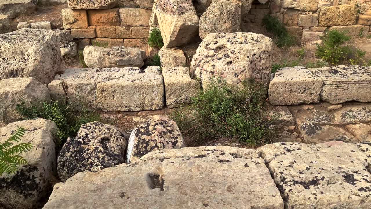 inclinación desde el antiguo reloj de sol grabado en la roca hasta el templo griego en el parque arqueológico de selinunte en sicilia, italia