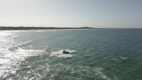 aerial dolly: jet ski riders get big air off surf wave at ocean beach