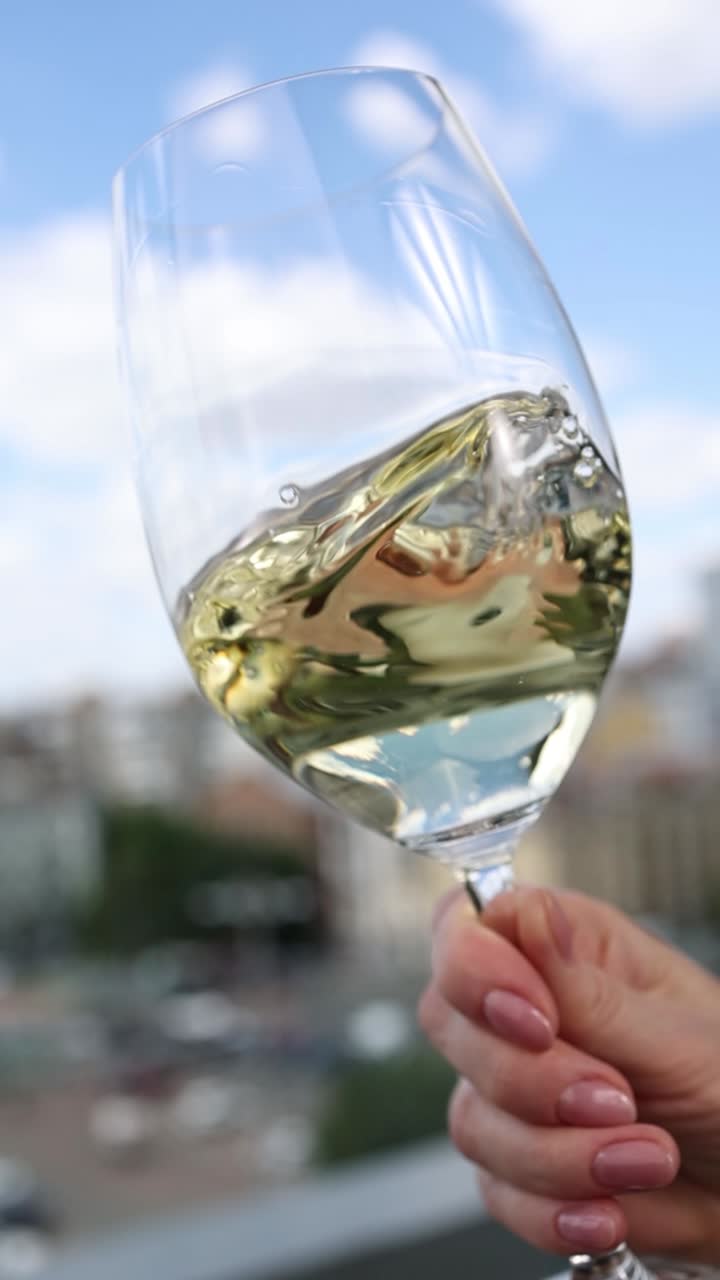 Gustando un bicchiere di vino bianco su una terrazza panoramica