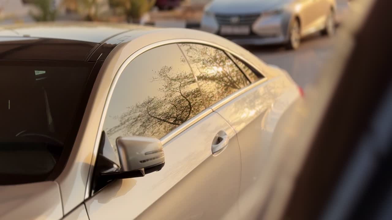 Cinematic 4K close-up of a sleek luxury car with golden-hour reflections on tinted windows. Perfect for auto ads, lifestyle visuals, travel, and transportation projects