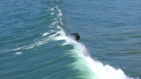 surfer riding a wave at pismo beach, california. 4k action footage from above.
