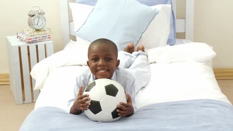 Panorama-of-AfroAmerican-little-kid-playing-with-a-soccer-ball-in-hid-bedroom