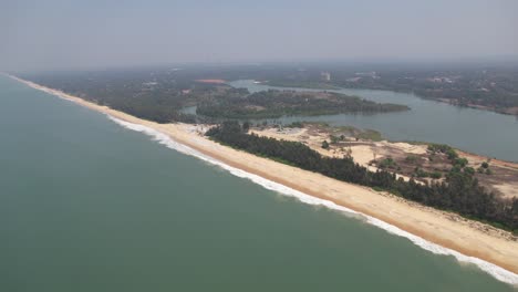 cinematic aerial shot of a beach with a river in the distance