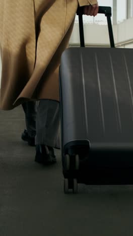 businessman walking with suitcase at airport