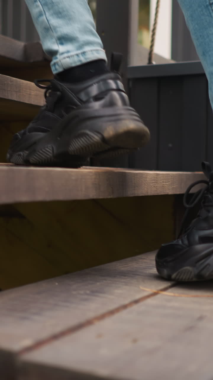 mujer en puntas de pies en las escaleras a la casa de glamping. dama camina a la puerta principal de la cabaña de campo después de pasar tiempo al aire libre. ejercicio matutino para la salud