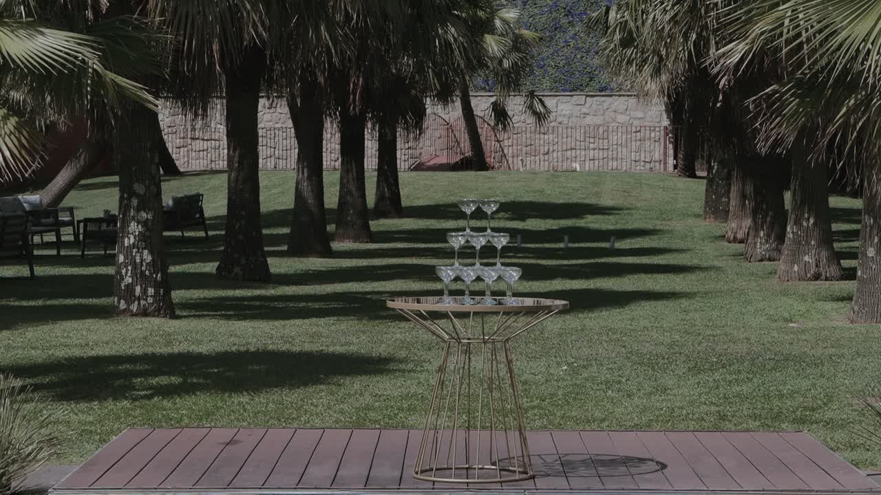 Tower of empty champagne glasses in garden event setting