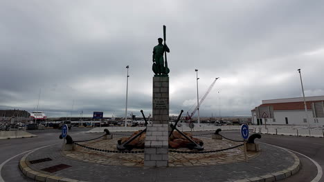 Pull-in-shot-of-an-empty-roundabout-with-a-fisherman-statue-in-Tarifa