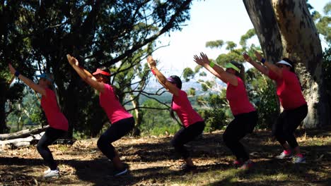 entrenadora ayudando a las mujeres mientras hacen ejercicio en el campamento de entrenamiento
