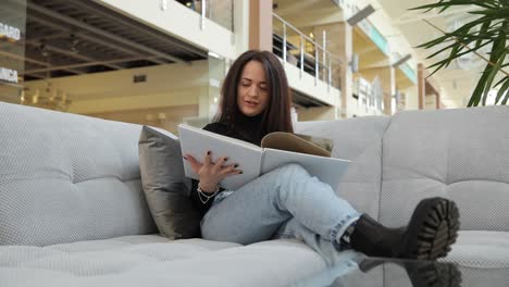 beautiful woman is looking at a sample of textiles in a furniture store choosing a beautiful woman is looking at a sample of textiles in a furniture store choosing a repair design