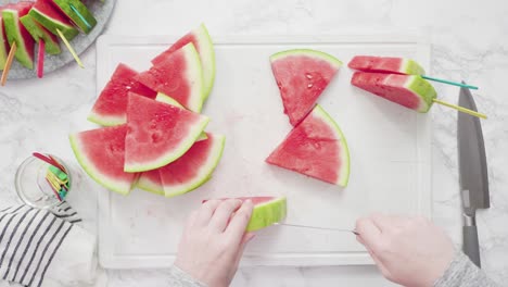 slicing red watermelon into small pieces