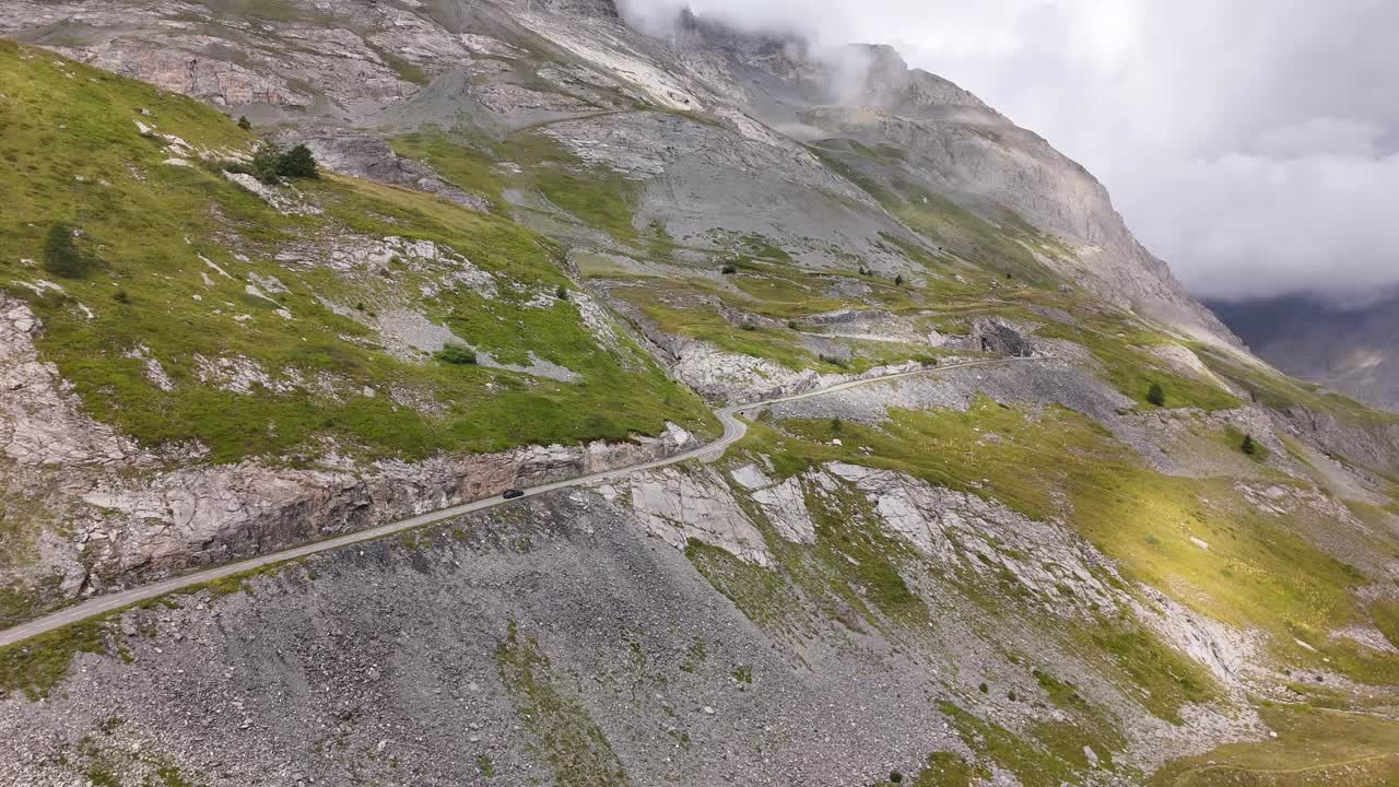 Ripresa aerea di un'auto che percorre una strada di alta montagna in 4K