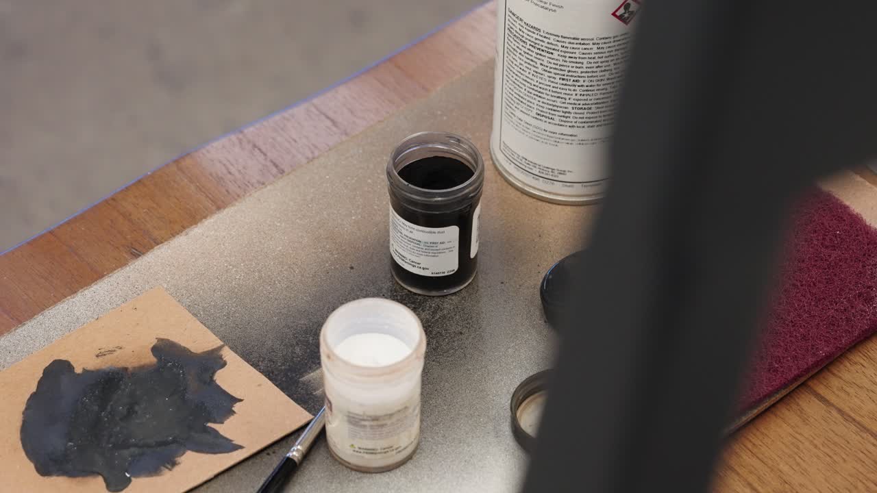 Foreground frame resolves to supplies on seat with black and white jars