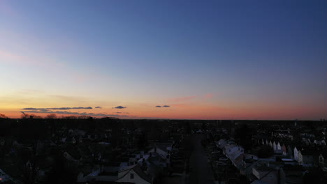 an aerial shot over a suburban neighborhood during a golden sunrise