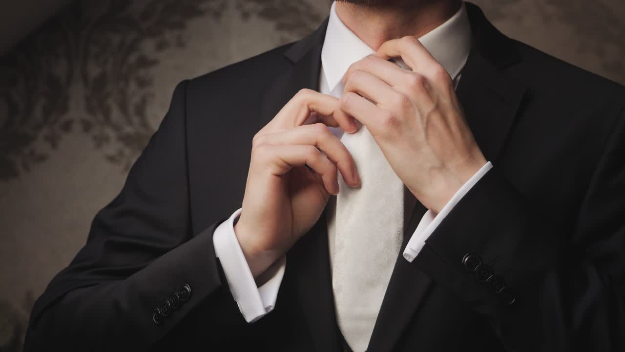Man adjusting tie, formal attire, business theme, elegant setting